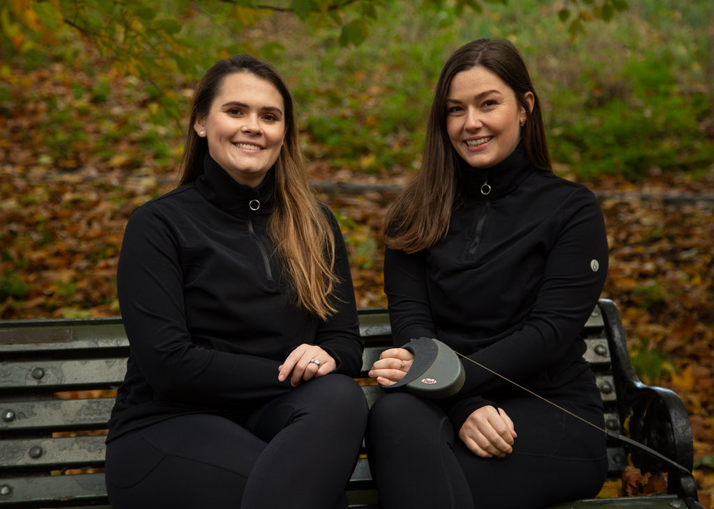 Belu Life founders sat in sustainable activewear on a park bench